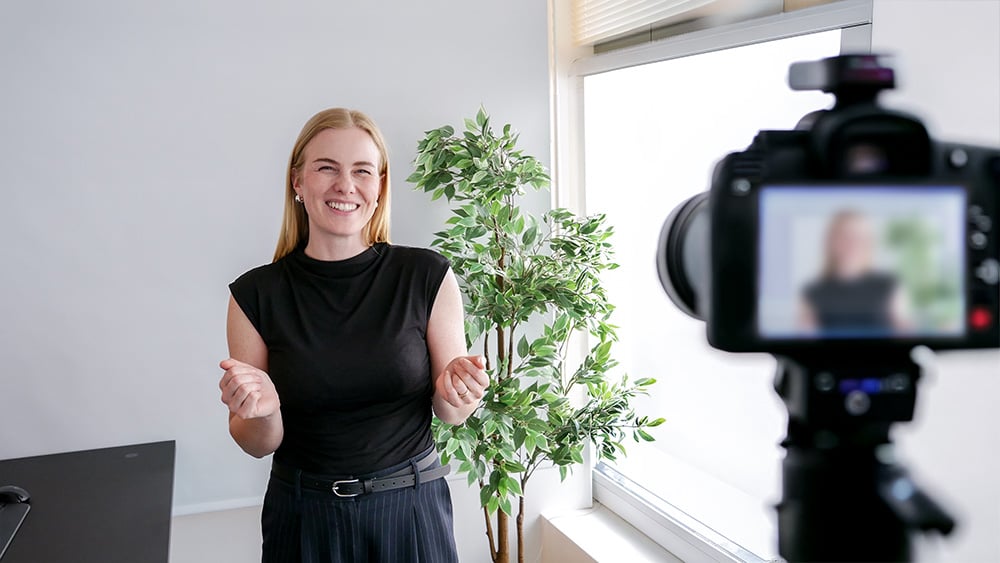 Tine presenterer foran et kamera i et lyst kontormiljø. Tine presenterer foran et kamera i et lyst kontormiljø.
